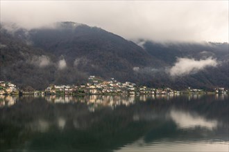 Village Brusino Arsizio on Lake Lugano in a Rainy and Cloudy Day with Reflection in Ticino,