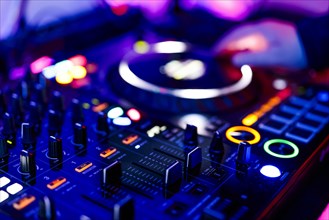 Hand of a DJ on a mixing desk, also called DJ controller or DJ console, at a party, Cologne, North
