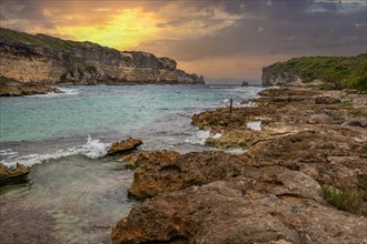 Rocky coast, long bay by the sea at sunset. Dangerous view of the Caribbean Sea. Tropical climate