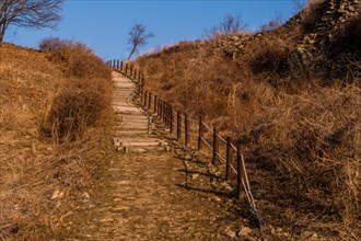 Wooden stairway up side of mountain on winter day under blue sky in Boeun, South Korea, Asia