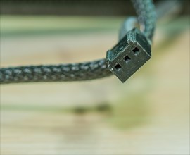 A close-up image of a frayed USB cable with visible wires, in South Korea