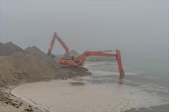 A foggy scene with an orange excavator by the water, in Ulsan, South Korea, Asia