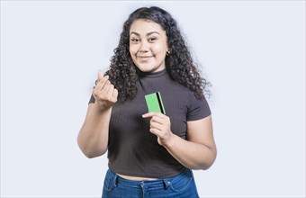 Attractive girl holding credit card making money gesture with fingers isolated, looking at camera