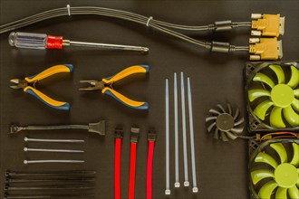 Flat lay of various computer tools and parts on black background