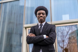 Portrait of a young and proud african businessman standing outside a financial building