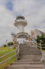 Entrance archway with a lighthouse in the background on an overcast day, in Ulsan, South Korea,