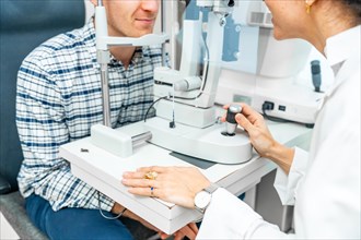 Part of an unrecognizable man checking the eye vision in ophthalmology clinic
