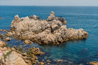 A view of a rugged coastline with clear ocean waters and rocky outcrops, in Ulsan, South Korea,