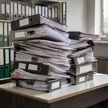 A chaotic-looking pile of files and documents on an office table, symbolising bureaucracy, AI