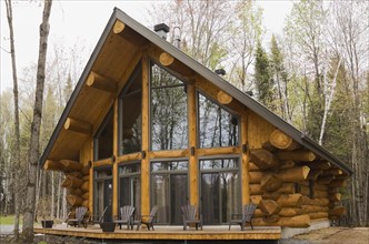 Luxurious Scandinavian style log home with large panoramic windows in spring, Quebec, Canada, North