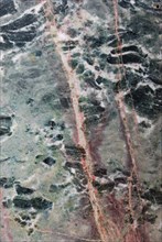 Green marble with distinctive pink veins, showcasing the intricate patterns of a polished stone