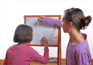Youngs girls drawing on the white board