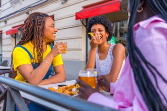Young beauty african friends enjoying meal together in an outdoor restaurant