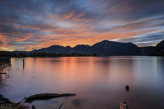 Dawn over a lake in front of mountains, long exposure, Lake Kochel, view of Rabenkopf and Jochberg,
