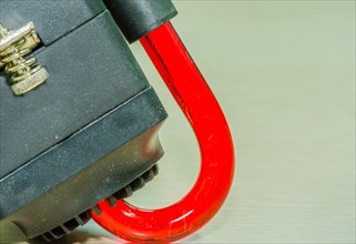A red plastic VGA connector clip on a green background, in South Korea
