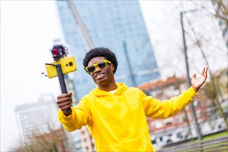African cool and young streamer recording on online video using mobile in the city