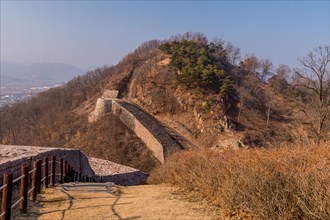 Landscape of mountaintop with sections of fortress wall made of flat stones located in Boeun, South