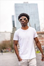 Vertical photo of a confident young african man walking in the city