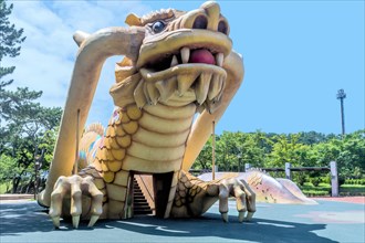 Playground equipment in the shape of a large dragon under a blue sky, in Ulsan, South Korea, Asia