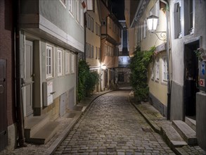 Narrow alley with cobblestones in the historic old town at dusk, Schwaebisch Hall, Hohenlohe,