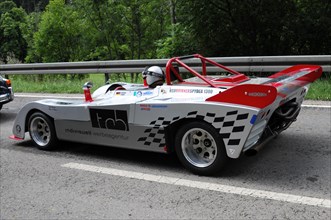 A white and red racing car with sponsor logos drives along a country road, SOLITUDE REVIVAL 2011,