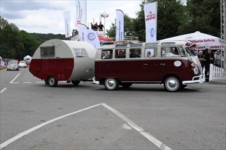 A classic red VW bus with attached caravan at an event, SOLITUDE REVIVAL 2011, Stuttgart,