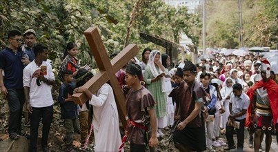 Christian devotees takes part in a perform to re-enactment of the crucifixion of Jesus Christ