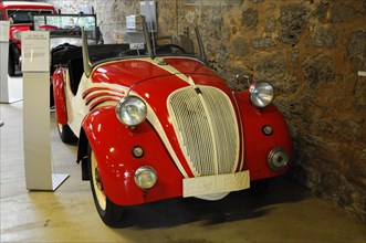 Deutsches Automuseum Langenburg, A red vintage car on display in a car museum, demonstrating