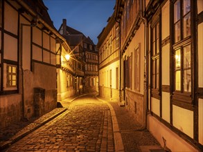 Narrow alley with half-timbered houses and cobblestones in the historic old town at dusk, UNESCO