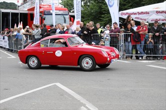 A red vintage car during a rally on the race track in front of spectators, SOLITUDE REVIVAL 2011,