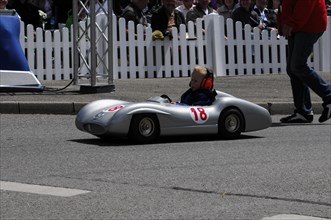 Young driver in a soapbox with number 18 passes spectators at the race track, SOLITUDE REVIVAL