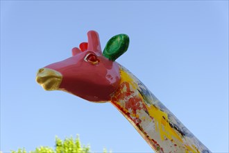 Head of a colourful giraffe statue in front of a clear blue sky, Marseille, Departement