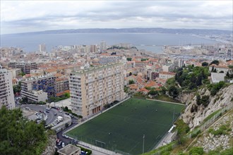 Marseille, panoramic view of a city with harbour, football pitch and high-rise buildings by the