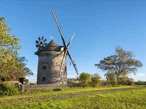 Old windmill behind a fence, casting long shadows in the evening sun, tower windmill, Endorf,