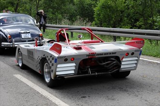 Rear view of a red and white racing car with a large rear wing on a road, SOLITUDE REVIVAL 2011,