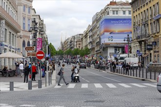 Marseille, A busy city street with people crossing the road and urban architecture, Marseille,