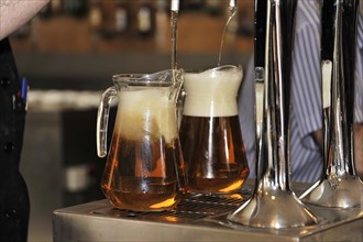 Solabrena, Two mugs of beer are freshly tapped at the bar with foam, Andalusia, Spain, Europe