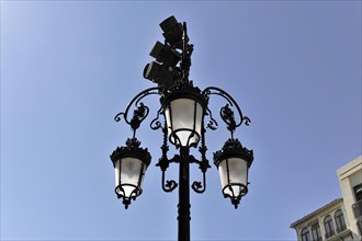 Granada, An ornate wrought iron street lamp against a clear blue sky, Granada, Andalusia, Spain,