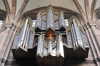 Speyer Cathedral, A large church organ with numerous pipes stands in the Gothic church interior,