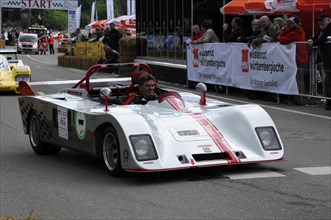 A white and red open-top racing car on a race track, driver in a red helmet, SOLITUDE REVIVAL 2011,