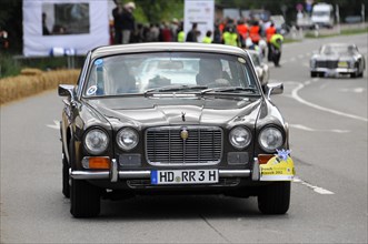 A black Jaguar classic car drives past spectators at a car race, SOLITUDE REVIVAL 2011, Stuttgart,