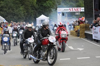 Motorcyclists at the starting line of a competition, surrounded by spectators, SOLITUDE REVIVAL