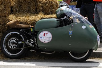 A stationary racing motorbike with the number 47 next to bales of straw, SOLITUDE REVIVAL 2011,
