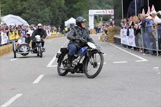Historic motorbike in racing mode in front of a crowd of spectators, SOLITUDE REVIVAL 2011,