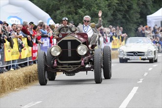 Passenger of a red classic car waves to the crowd at a car race, SOLITUDE REVIVAL 2011, Stuttgart,