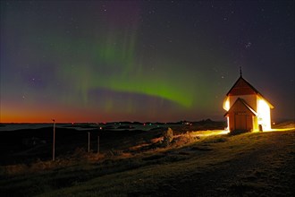 Northern lights (aurora borealis) merging with sunset, Petter Dass Chapel, night shot, Lovunden,