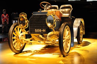 Vintage vehicle presented at an exhibition with warm light, Mercedes-Benz Museum, Stuttgart,