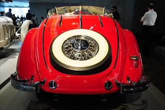 Rear view of a red vintage convertible with eye-catching chrome details, Mercedes-Benz Museum,