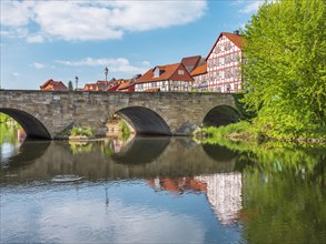 Stone bridge over the river Werra and half-timbered houses in the historic old town of Allendorf,