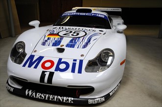 Deutsches Automuseum Langenburg, A white Porsche racing car with sponsor logos on display in a car